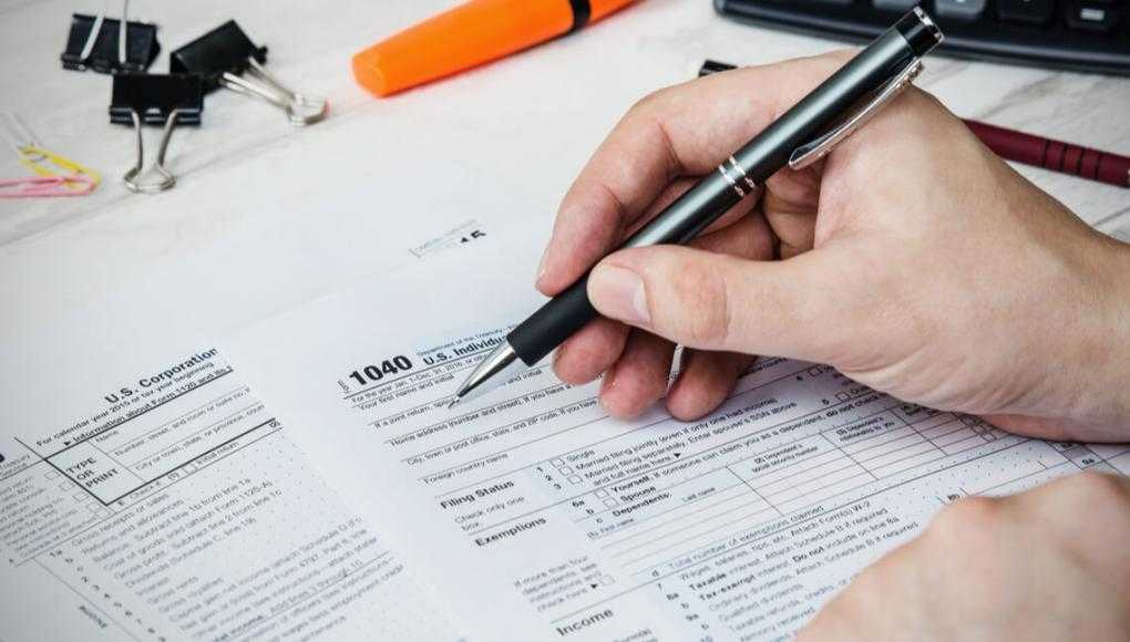 Man filling US tax form. tax form us business income office hand fill concept
